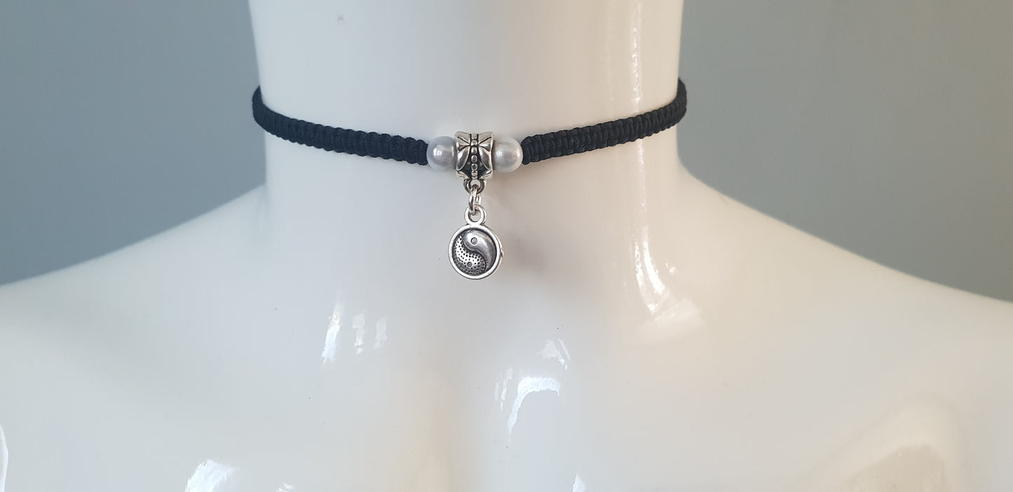 This yin yang choker necklace is handmade using a tibetan silver yin yang charm, on black cord with white beads either side and silver beads on the ends of the cords.